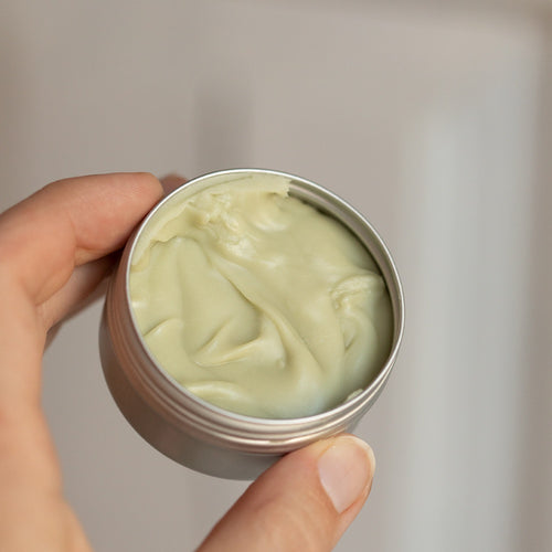 Hand holding HOIA Cream Deodorantbackground