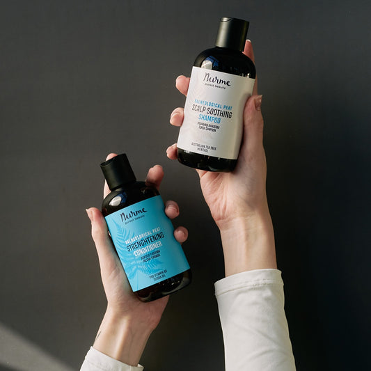 Two bottles of Nurme hair care products held by a person